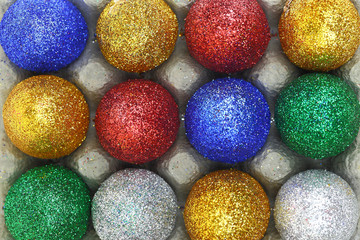Colorful glitter eggs in carton egg packaging closeup