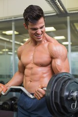 Fototapeta na wymiar Shirtless muscular man lifting barbell in gym