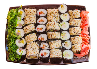 large plate with a wide selection of sushi, seaweed and ginger