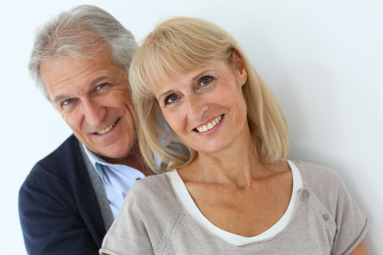 Portrait of senior couple embracing each other, isolated