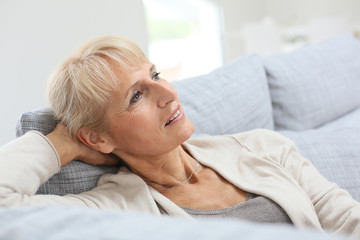 Fototapeta premium Senior woman relaxing in sofa and looking away
