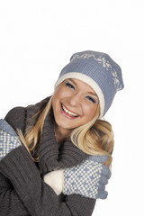 Junge blonde Frau in Pullover, Mütze und Handschuhe