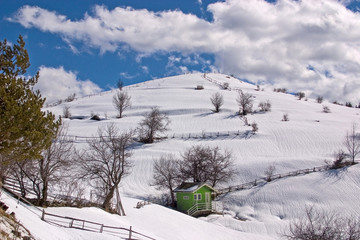 Fototapeta na wymiar Snow mountain hill with hut