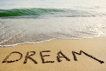 word dream written in the sand - positive thinking concept