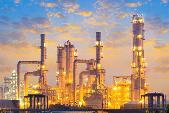 Panoramic Thaioil Refinery at blue hour in Laem Chabang, Chonburi, Thailand, with illuminated distillation towers and pipelines for petroleum processing and industrial energy.