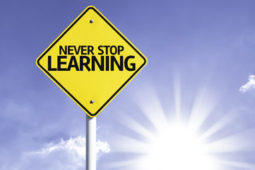 Never Stop Learning road sign with sun background