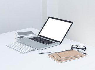 blank screen laptop computer with notebook on the table