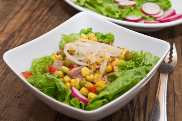 Salad with tuna and Mung bean sprouts, on a wooden table