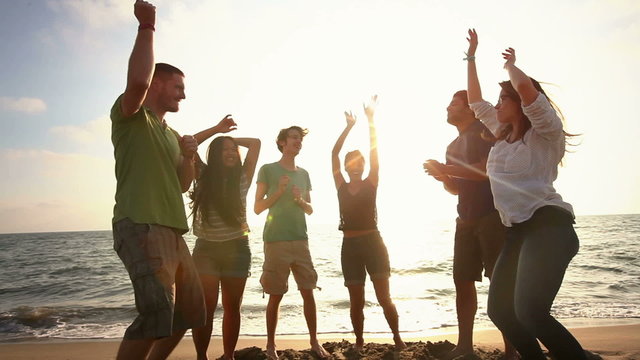 Multiracial Group Dancing at Beach