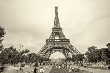 Tourists enjoying Eiffel Tower view from Champs de Mars gardens