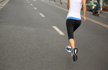 Runner athlete running on city road.  
