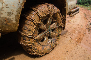 close up of off road car tire with chain on it