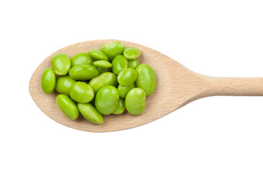 Green soybeans on wooden spoon isolated on white