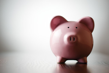Pink piggy bank on a colorful grey background