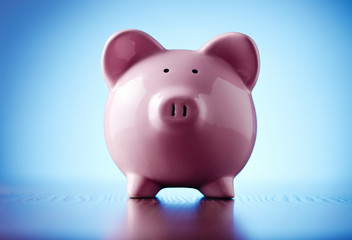 Pink piggy bank on a colorful blue background