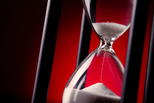 Egg timer or hourglass on a red background