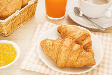 Croissants, coffee cup and juice on table, filtered image
