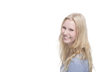 Naklejka premium Junge blonde Frau lächelt gegen weisser Hintergrund