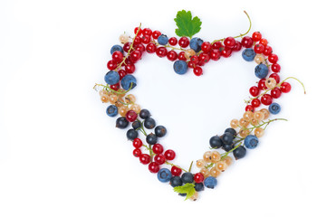 assorted garden berries in a heart-shaped, top view, isolated