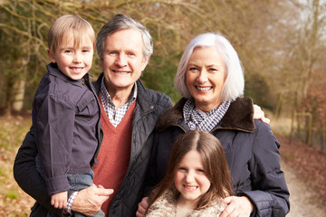 Fototapeta premium Grandparents With Grandchildren On Walk In Countryside