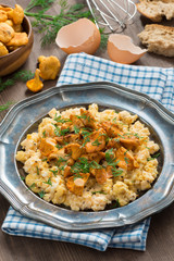 scrambled eggs with chanterelles and fresh dill on a plate