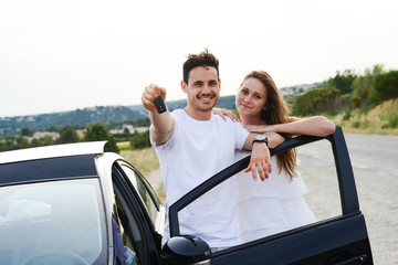 happy young couple driving new car holiday trip summertime