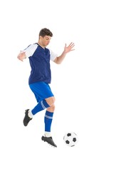 Fototapeta premium Football player in blue jersey kicking ball