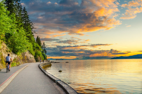 Sunset over The Seawall of Vancouver with cyclist in motion