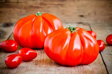 Fresh red heirloom tomatoes on a wooden background