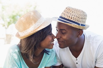 Happy couple lying in garden together touching noses