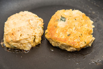 Raw and Browned Crab Cakes in Pan