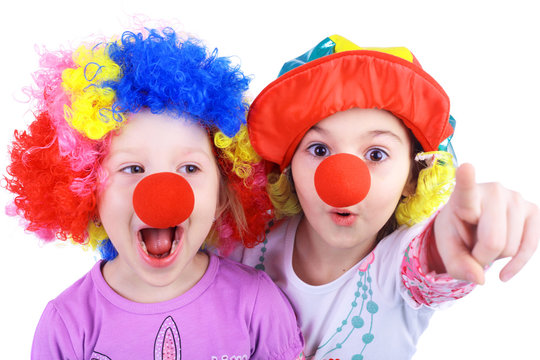 Two kids playing clowns in bright wigs