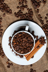 Coffee cup with coffee beans, cinnamon and aniseed.