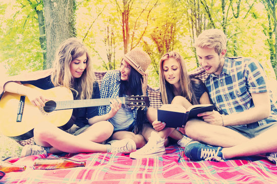 young adults have fun with guitar at the campground