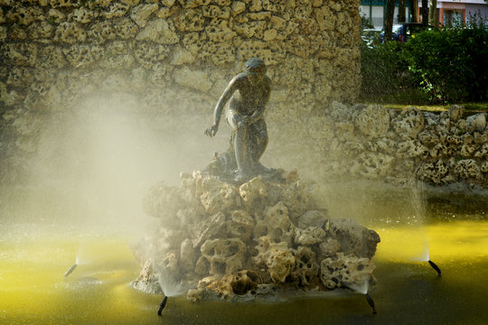 rayos de luz iluminando una estatua entre las gotas de agua