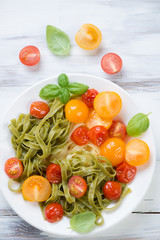 Boiled tagliatelle with fried tomatoes and fresh green basil