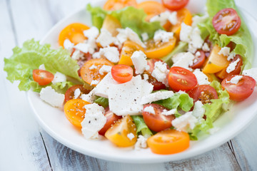 Salad with sliced tomatoes, feta cheese and salad leaves