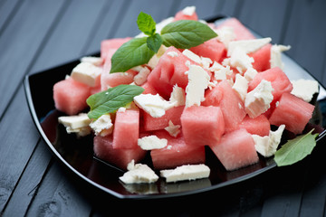 Glass plate with watermelon cubes and feta cheese salad