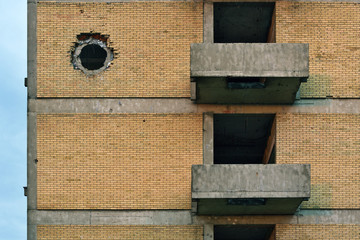 Tank shell hole on the building brick wall