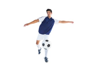 Fototapeta na wymiar Football player in blue kicking ball