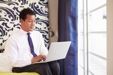 Businessman Working On Laptop In Hotel Room