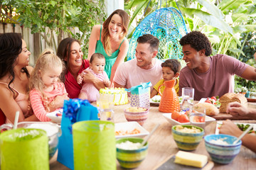 Group Of Families Celebrating Child's Birthday At Home