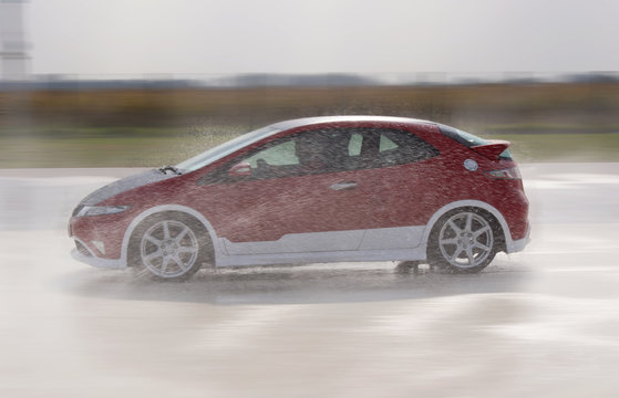 Fast car driving through the water on the road