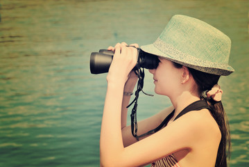 Fototapeta na wymiar toned image teen girl looking through binoculars side view