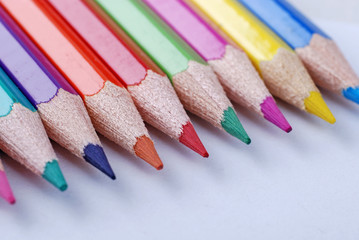 Multicolored crayons in a row on white background.