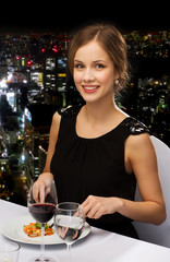 smiling young woman eating main course