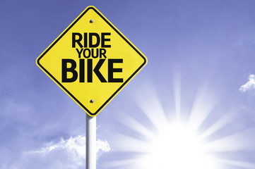 Ride your Bike road sign with sun background