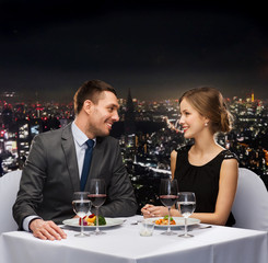 smiling couple eating main course at restaurant
