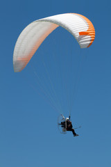 Propelled paraglider on clear sky