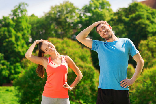 smiling couple stretching outdoors